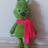 Grinch, amigurumi figura, zöld zseníliafonálból horgolt, piros sállal, morcos arckifejezéssel és bozontos textúrával