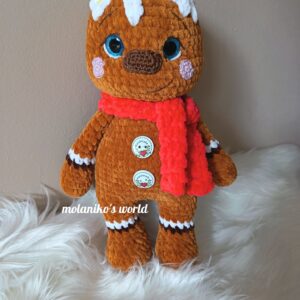 Mézi, amigurumi mézeskalács figura, zseníliafonálból horgolt, piros sállal, fehér cukormáz díszítéssel és ünnepi gombokkal.